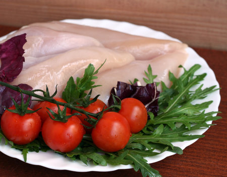 Ready for cooking raw chicken fillet with ruccola, radicchio and cherry tomatoesの写真素材