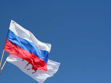 russian flag on a pole against blue sky の写真素材