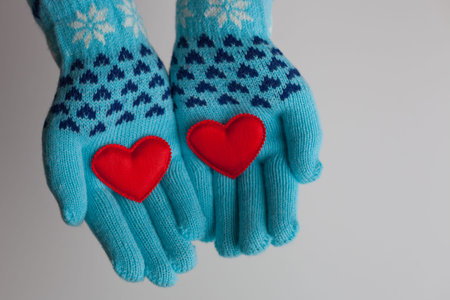 Read hearts in hands in warm gloves on Valentine