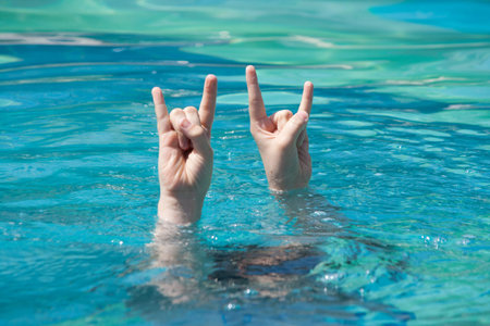 two hands raising out of water