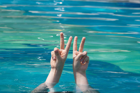 two hands raising out of water