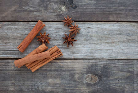 cinnamon sticks and anise stars on rustic wooden backgroundの写真素材