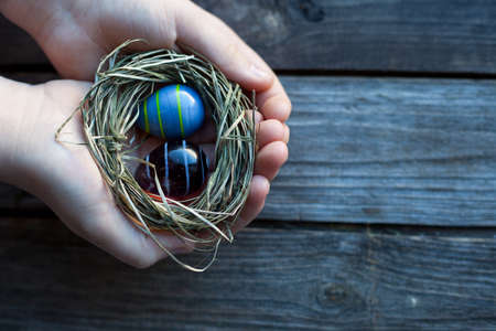 easter decoration - easter glass eggs in handsの写真素材