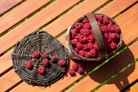 fresh raspberry in a basket on wooden table sunlight
