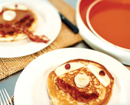 plates of pancakes with faces on them in baconの写真素材