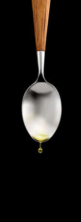 spoon with olive oil dripping from itの写真素材
