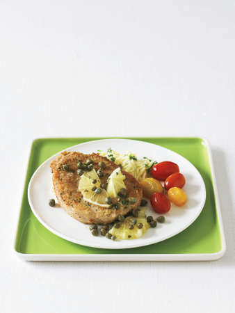 pork piccata with sauteed grape tomatoesの写真素材