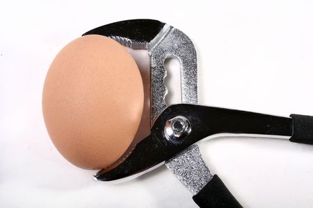 An egg in a vice grip.の写真素材