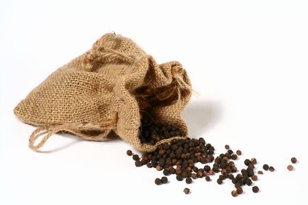Black pepper spilling out of a small hessian bag.の写真素材