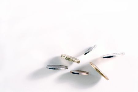 Six UK coins balancing on a white background.の写真素材
