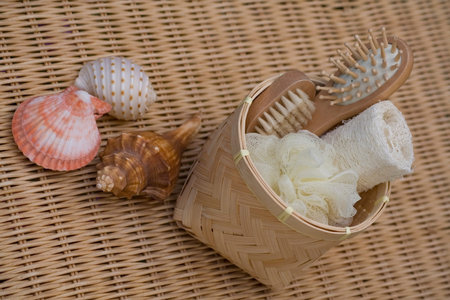 A selection of therapy products on a wicker mat with some seashells.