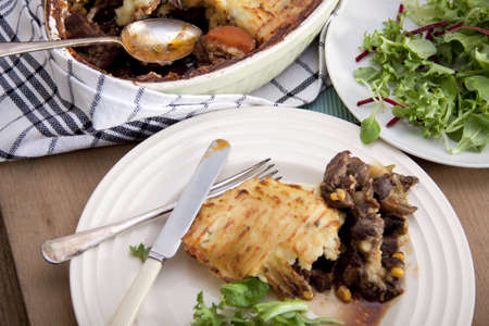 A delicious home made meat pie on a wooden table that makes your mouth water. の写真素材