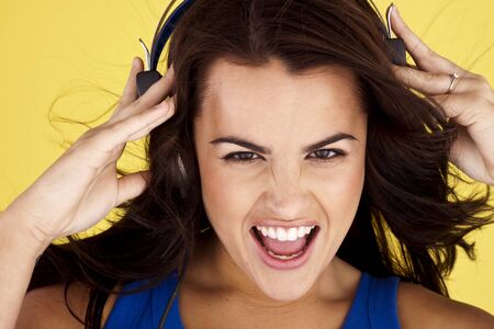 Young woman listing to music on a set of headphones. の写真素材