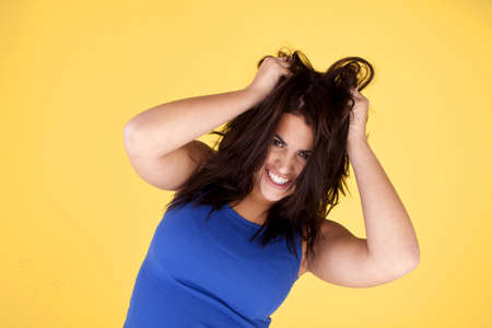 An attractive woman being happy with herself in playfully pulling her hair.の写真素材