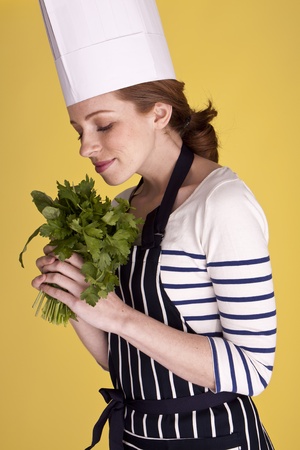 Portrait of an attractive female chef over a yellow background. の写真素材