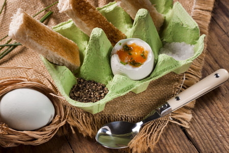 Free range eggs and toasted bread soldiers served in a green egg container  