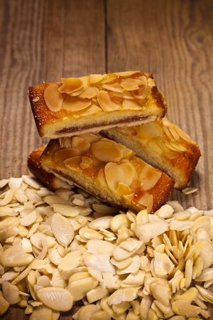 Two delicious almond sponge slices on a wooden table. の写真素材