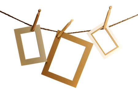 Three frames hanging from a rope over a white background の写真素材