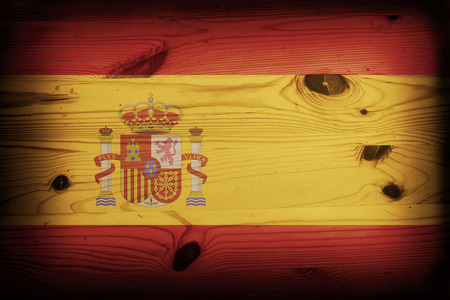 Spanish flag over a grunge wooden background の写真素材