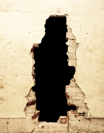 Dilapidated wall with black hole that can be removed.の写真素材