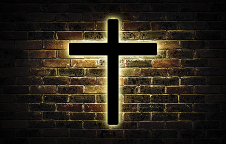 Wooden crucifix hanging on a brick wall.の写真素材