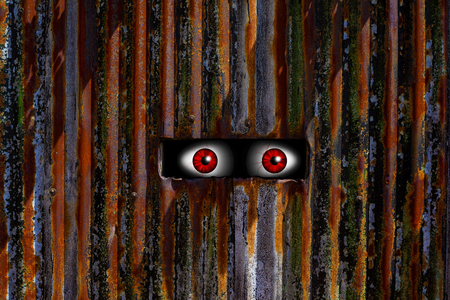 Abstract image of spooky eyes looking trough a hole.の写真素材