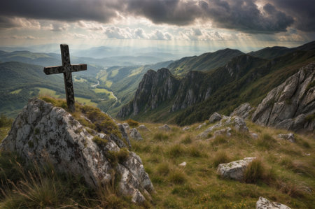 Cross on the top of the mountain with rays of light coming through the cloudsの素材