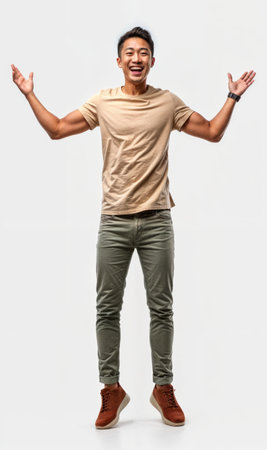 Full length portrait of a happy young asian man standing on white backgroundの素材