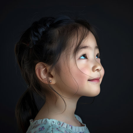 Profile of a young girl looking up with a dark backgroundの素材