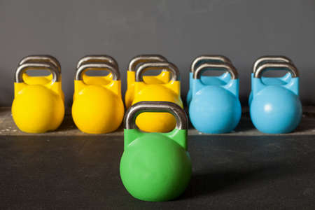 colorful kettlebells in a row in a gym - focus on the front kettle bellの写真素材