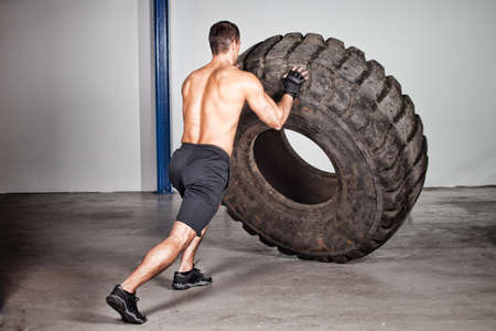 crossfit training - man flipping tireの写真素材