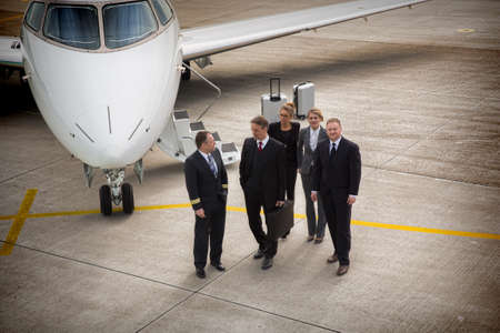 executive business team in front of corporate jet pilot talking toの写真素材