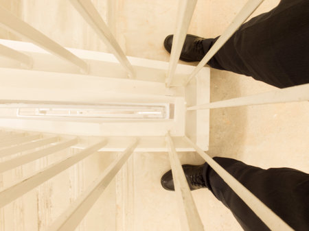View of person looking down the handrail from high rise building