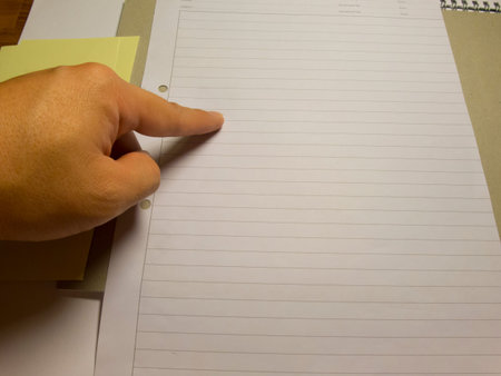 Finger pointing onto blank writing paper stock image