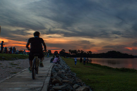 Foreign worker cycling and enjoying the sunset at Kranji Damの写真素材