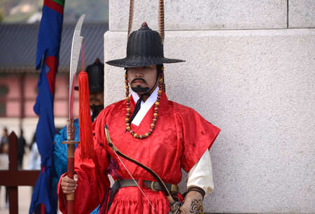 SEOUL, KOREA - OCTOBER 22 : Korean guard dressed in a red uniform and holding a lance stands at the entrance to the Gyeongbokgung Palace in Seoul, Korea on October 22, 2014.のeditorial素材