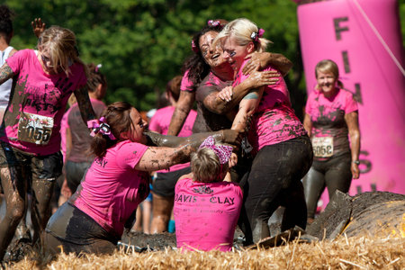 Atlanta, GA , USA - April 28:  A group of unidentified women competing in the Dirty Girl Mud Run, try to pull another woman down into the mud pit as they near the finish line of the women only obstacle course race.のeditorial素材