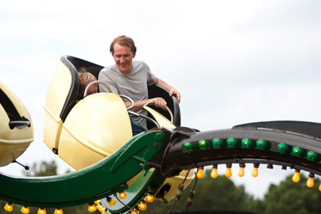Lawrenceville, GA, USA - September 15, 2012:  An unidentified man and boy enjoy a fast moving carnival ride on the midway at the Gwinnett County Fair.のeditorial素材