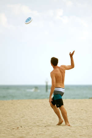 Ft. Lauderdale, FL, USA - December 29, 2012:  An unidentified man throws a frisbee on the beach of a Ft. Lauderdale resort over the Christmas holidays. のeditorial素材