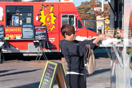 Atlanta, GA - November 17, 2012:  An unidentified customer buys food from a high-end food truck at...