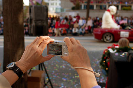 Atlanta, GA, USA - December 1, 2012:   A woman's hands hold a point and shoot camera as she captures moments from the annual Atlanta Christmas parade in downtown Atlanta.のeditorial素材