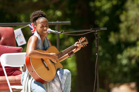 Atlanta, GA, USA - May 25, 2012:  A female singer plays acoustic guitar and sings at the GREAT festival, a spring festival celebrating Great Britain and the United Kingdom.のeditorial素材