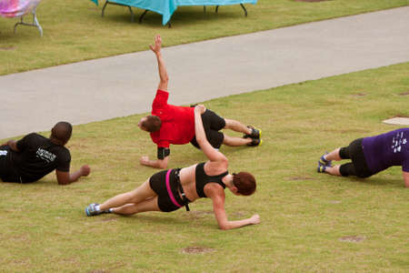 Atlanta, GA, USA - June 29, 2013:  Men and women work out in a fitness boot camp on a grassy field in the old 4th ward of Atlanta.のeditorial素材