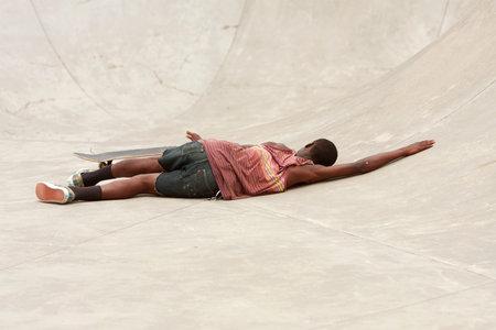 Atlanta, GA, USA - June 29, 2013:  A teenager lays on the concrete after wiping out during a...