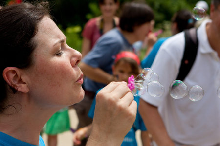 Roswell, GA, USA - July 13, 2013:  An unidentified volunteer blows bubbles as patrons exit the...