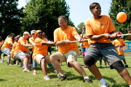 Atlanta, GA, USA - September 7, 2013:  A team pulls hard in the tug-of-war competition at A Day For Kids, an event where adults play kids games to beneft the Girls and Boys Clubs of America.のeditorial素材