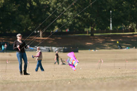 Atlanta, GA, USA - October 26, 2013:  A woman holds on and steers large kite at the World Kite Festival in Piedmont Park.のeditorial素材