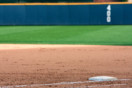 Empty baseball field highlights first base and outfield wall 