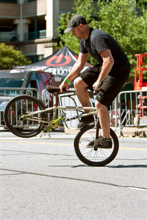 Athens, GA, USA - April 26, 2014:  A man practices his flatland tricks before the start of the BMX Trans Jam competition on the streets of downtown Athens.のeditorial素材