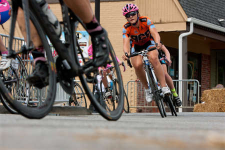 Duluth, GA, USA - August 2, 2014:  A group of female cyclists race into a turn on a downtown Duluth street as they compete in the Georgia Cup Criterium event.のeditorial素材